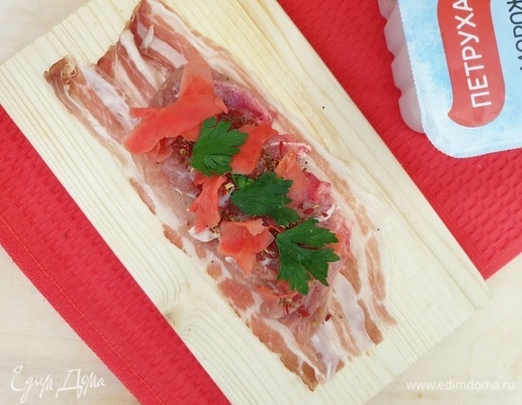 На курицу кладем несколько лепестков маринованного имбиря и листья петрушки.