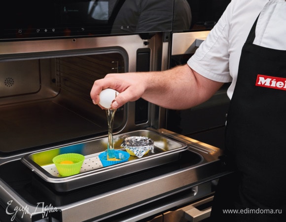 Сварите яйца-пашот. Для этого разбейте каждое яйцо и поместите отдельно в силиконовую формочку для кекса. Накройте фольгой и готовьте на пару в пароварке с СВЧ 4 минуты.