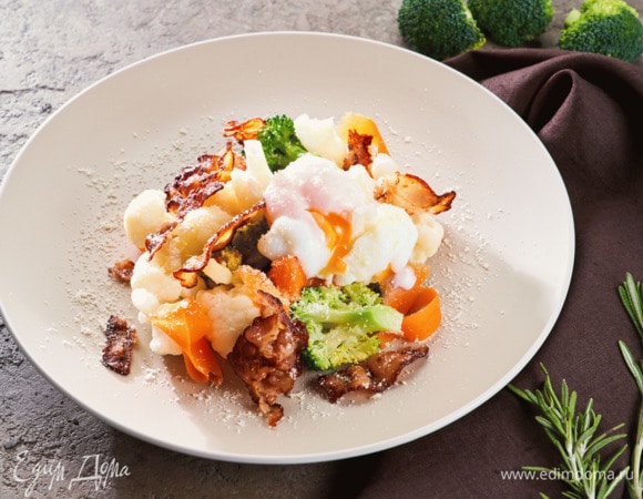 Выложите овощи, бекон, положите на каждое блюдо по яйцу-пашот. Посыпьте тертым пармезаном и подавайте.