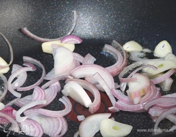 В сковороду-вок влить масло, добавить лук и чеснок.