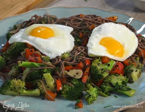 На тарелку выложить лапшу с овощами, сверху — яйца.