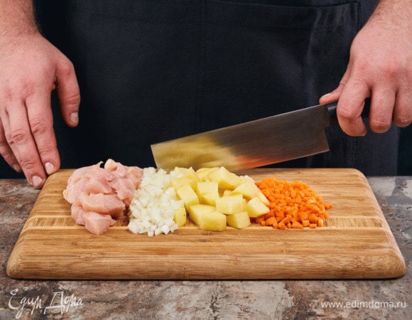 Филе нарежьте на небольшие кубики. Картофель, морковь и лук почистите, нарежьте кубиками.