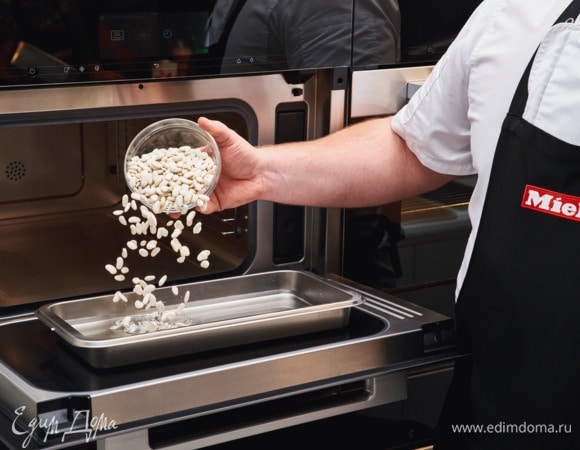 Промойте фасоль, выложите в неперфорированный контейнер и налейте воды. Отваривайте фасоль в пароварке с СВЧ Miele DGM 7840 на пару при температуре 100°С в течение 50 минут, а затем слейте воду и немного помните толкушкой.