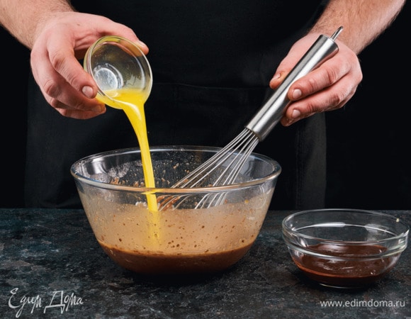 Влейте в тесто растопленный шоколад и масло, оставьте на 2 минуты, а затем перемешайте.