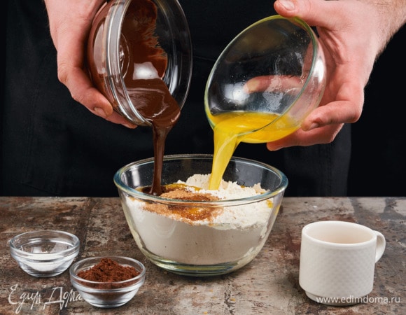 Добавьте растопленный шоколад и сливочное масло, разрыхлитель, какао и кофе. Перемешайте до получения однородной массы.