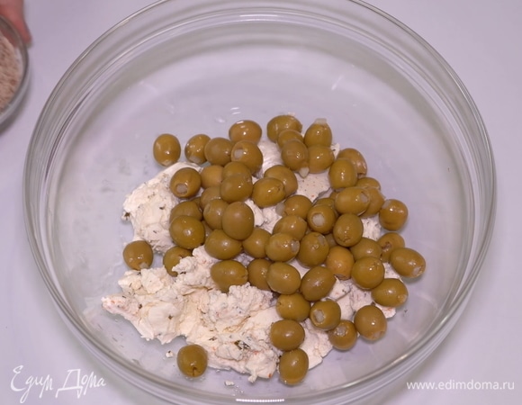 Отправляем к сливочному сыру фаршированные оливки. А можете использовать классические оливки без косточки.