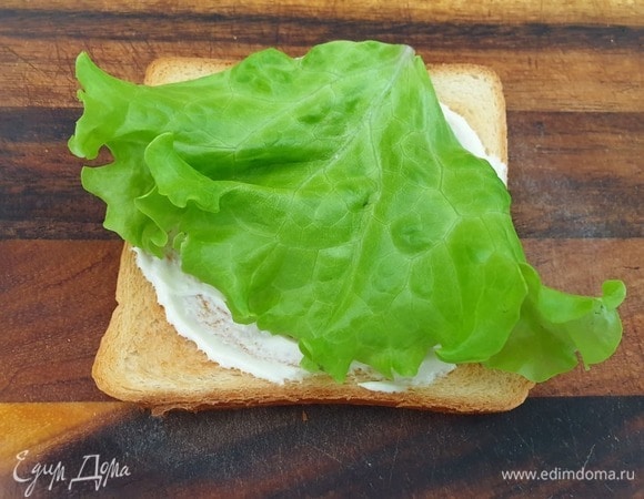 Хлеб смазываем майонезно-горчичным соусом, кладем лист салата.