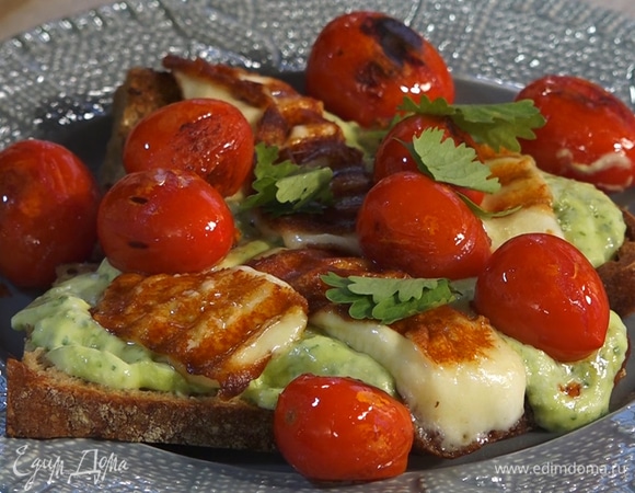 На тарелку выложить хлеб, сверху соус, далее сыр и помидоры. Украсить бутерброды кинзой.