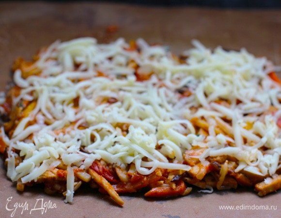 Раскладываем овощи в квадрат по форме пласта нашего раскатанного теста. Размер квадрата должен быть меньше размеров теста на 1 см с каждой стороны. Посыпаем овощи тертым сыром. Таким образом связь между овощами и донышком с помощью расплавленного сыра будет прочнее.