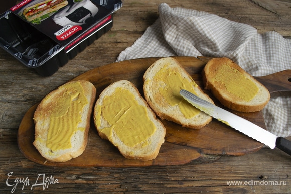 Чуть-чуть подрумяниваем в тостере ломтики белого хлеба, смазываем горчицей. Не пережаривайте хлеб, ему еще в духовку предстоит отправиться.