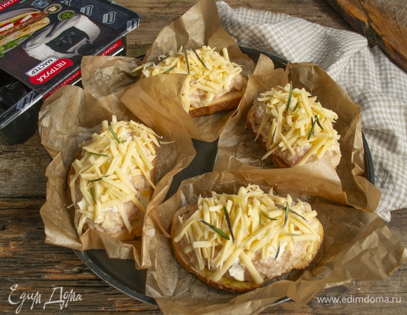 Вырезаем небольшие квадраты из пергамента для выпечки, смазываем бумагу капелькой растительного масла, кладем на противень. Выкладываем на пергамент бутерброды. Смазываем котлеты майонезом, обильно посыпаем тертым сыром. Для аромата можно добавить немного розмарина или тимьяна.