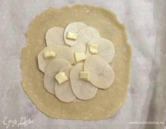 Тесто достать из холодильника и разделить на две половины. Получается две небольшие галеты. Каждую часть теста раскатать в круглый пласт толщиной 3–5 мм. Выкладываем картофель, немного солим, и сверху — несколько кусочков сливочного масла, чтобы галета была сочная.