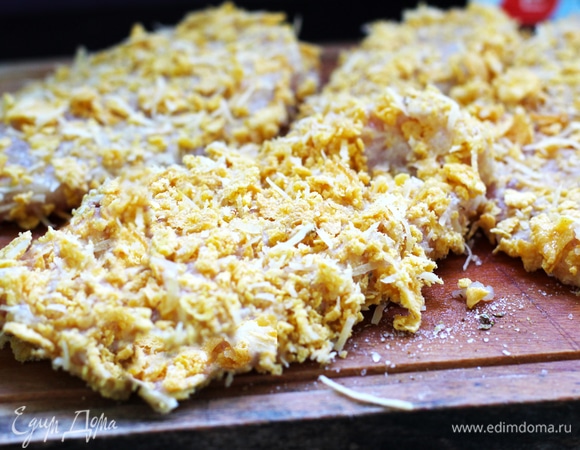 Подготовить два блюда. В одно насыпать муку, а во второе разбить два яйца и размешать вилкой. Теперь каждую отбивную по очереди сначала слегка обвалять в муке, стряхнуть излишки муки. Затем обмакнуть в яичную смесь. В конце обвалять в кукурузной крошке, переворачивая и придавливая пальцами отбивную к панировке, чтобы она хорошо закрепилась на отбивных. Таким образом подготовить все куриные отбивные.