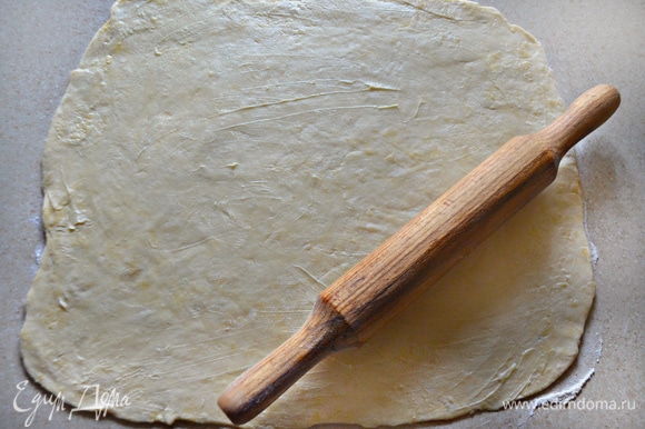 Раскатайте тесто в прямоугольный пласт толщиной около 5 мм, смажьте оставшимся сливочным маслом и плотно сверните в рулет (внутри не должно быть воздуха).