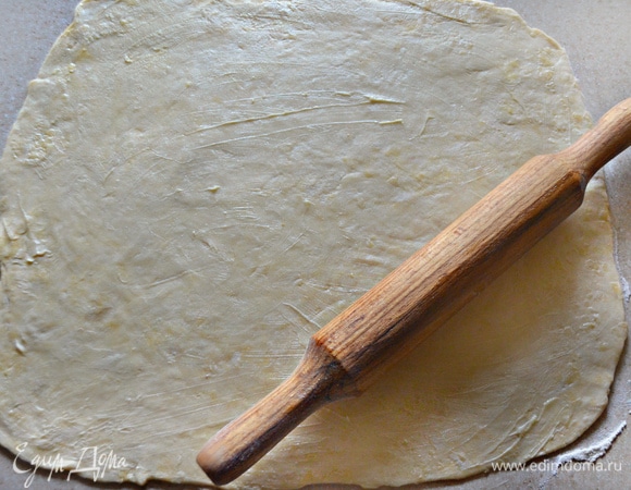 Раскатайте тесто в прямоугольный пласт толщиной около 5 мм, смажьте оставшимся сливочным маслом и плотно сверните в рулет (внутри не должно быть воздуха).