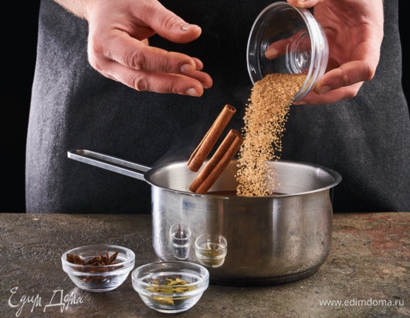 Добавьте в кипяток сахар, палочки корицы, кардамон и бадьян.