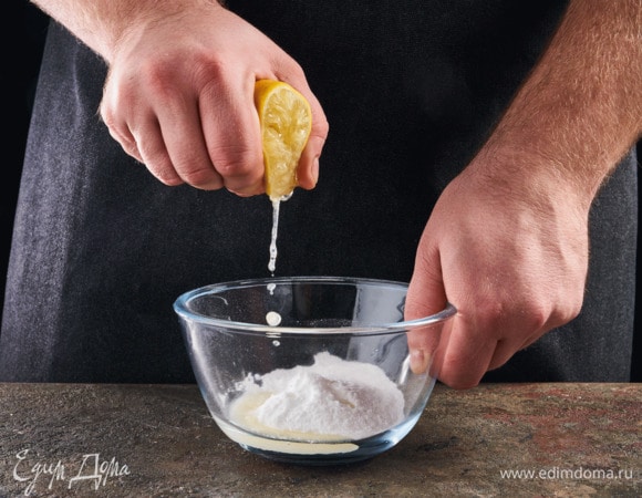 Займитесь глазурью. В глубокую миску выжмите половину лимона, добавьте 80 г сахарной пудры. Перемешайте, дайте постоять.