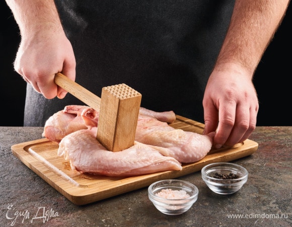 Цыпленка разрежьте вдоль грудки, обсушите бумажным полотенцем. Переверните его внутренней сторон вниз и немного отбейте. Смажьте солью и перцем.