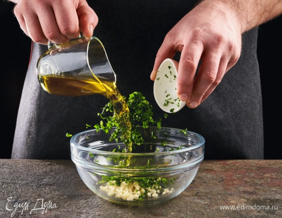 Чеснок почистите, кинзу помойте. Мелко порубите чеснок и кинзу. Смешайте с маслом.