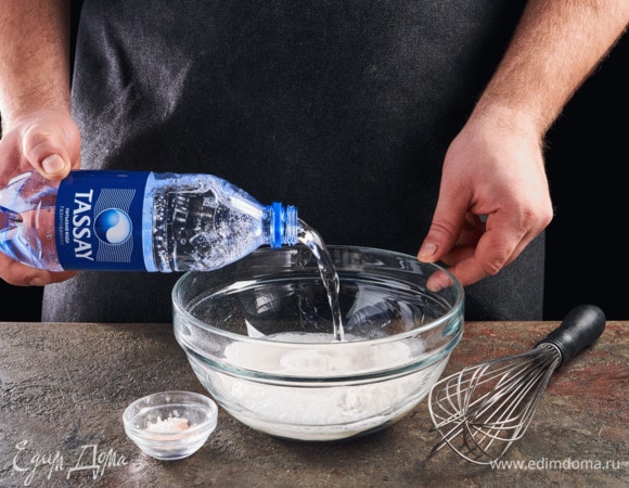 Налейте газированную воду Tassay, посолите. Перемешайте. Тесто по консистенции должно напоминать жирные сливки.
