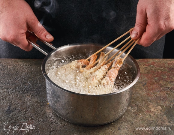 В сотейник налейте растительное масло (по высоте должно быть около 5 см). Разогрейте его. Окунайте креветки в горячее масло. Обжаривайте до золотистого цвета, перевернув один раз, около 3 минут.