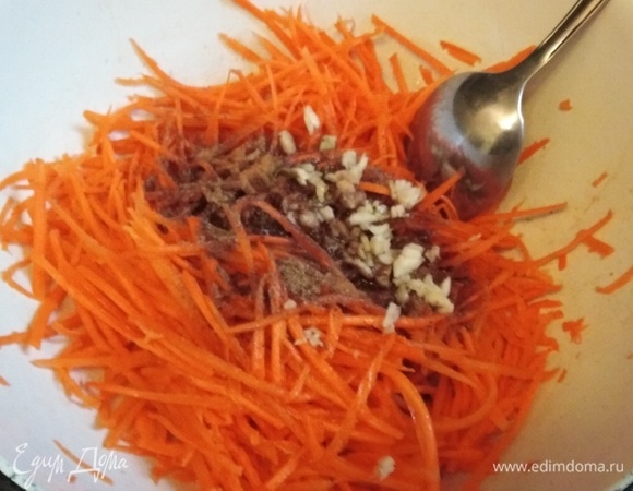 Морковь натереть на специальной терке. Чеснок измельчить ножом. Соединить морковь, чеснок, кориандр, сахар, соль, паприку, острый перец, уксус и растительное масло. Перемешать. Дать настояться в течение 30 минут.