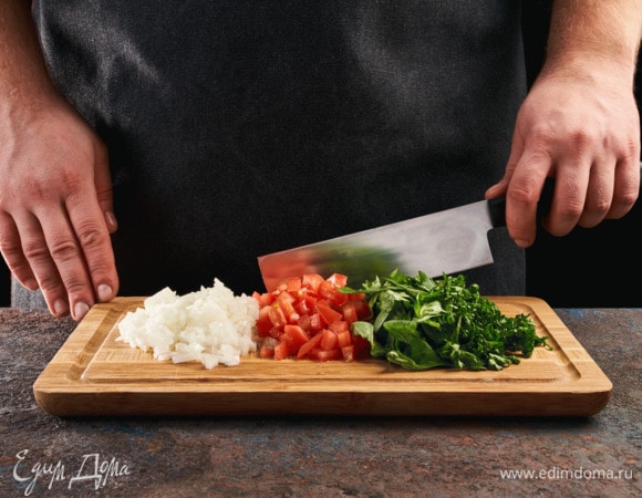 Лук почистите и мелко нарежьте, помидоры нарежьте кубиками, зелень мелко нарубите.