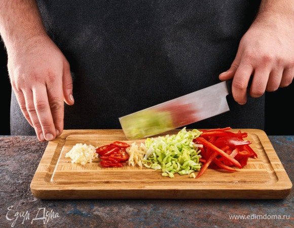 Лук-порей нарежьте полукольцами, перцы почистите и нарежьте тонкими полосками. Перец чили мелко нарежьте. Имбирь нарежьте тонкой соломкой, чеснок мелко порубите.