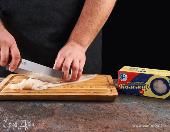 Тушки кальмаров ТМ «Океанрыбфлот» разморозьте, снимите кожу, промойте. Разрежьте тушки напополам и сделайте с внутренней стороны надрезы в виде сетки (будьте аккуратны, чтобы кусочки остались целыми). Затем разделите на полоски по 1 см.