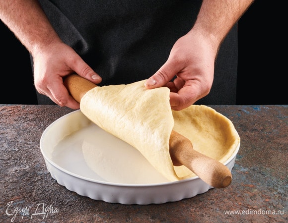 Противень смажьте растительным маслом. Раскатайте тесто, выложите его, закрепив его на бортиках противня.