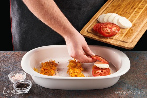 На рыбу выложите обжаренные овощи, потом кружочки помидоров и сыра. Запекайте в духовке 15 минут при 185°С.