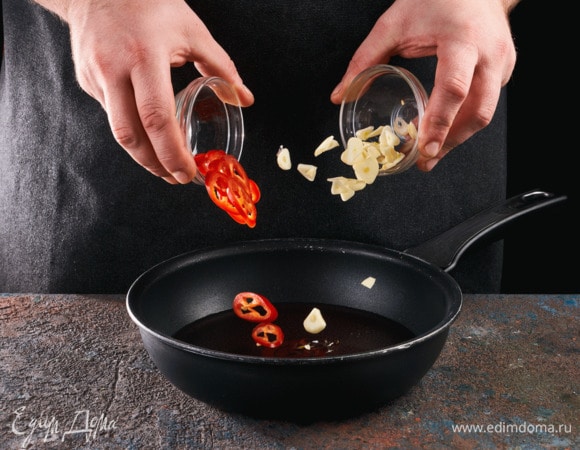 Чеснок и перец чили нарежьте кружочками. В сковороде слегка нагрейте оливковое масло, обжарьте в нем чили и чеснок до золотистого цвета.