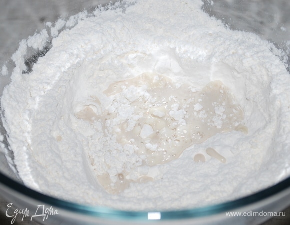 Сделаем тесто для наших булочек бейгл. В теплой воде размешайте свежие дрожжи. В муку добавьте соль, сахар, перемешайте. Сделайте углубление в муке и вылейте туда воду с дрожжами.