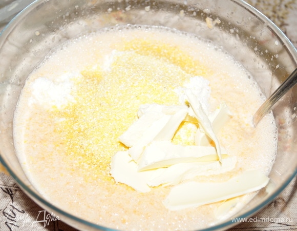Добавьте кукурузную и манную крупу, сливочное масло и творог 9 %.