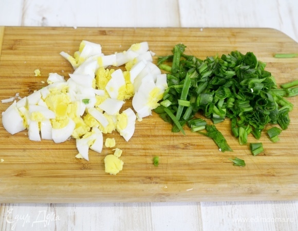 Два яйца отварите вкрутую, лук вымойте. Нарежьте яйцо и лук помельче.