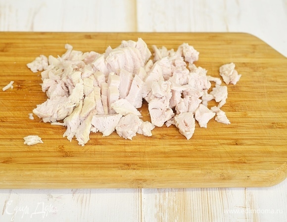 Куриное филе отварите в течение 20 минут в чуть подсоленной воде, охладите и нарежьте небольшими кусочками.