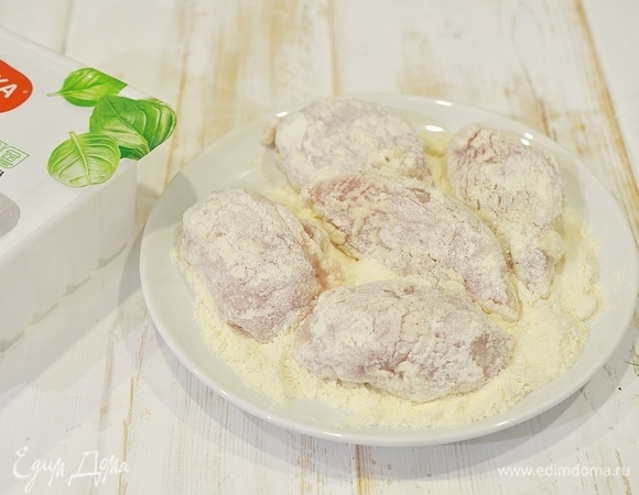 В муку добавьте соль. Можно добавить немного любимых приправ. Обваляйте каждый кусочек курицы.