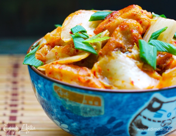 Оставить 1 ст. л. масла в сотейнике, добавить туда кунжутное масло. Обжарить 1 луковое перо, чеснок и имбирь (не доводить до изменения цвета). Влить мирин (можно заменить белым вином) и соевый соус. Добавить в сотейник курицу, обжарить 1–2 минуты вместе, помешивая. Выложить в сотейник кимчи, размешать, обжарить 1 минуту.