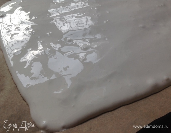 Духовка — на 150°C. Противень застилаем пергаментом глянцевой стороной вверх. Пергамент должен быть отличного качества, чтобы легко снять готовую меренгу. В белки добавляю крахмал, аккуратно мешаю деревянной лопаткой. Выливаю на противень. Обратите внимание на глянцевый цвет белков.