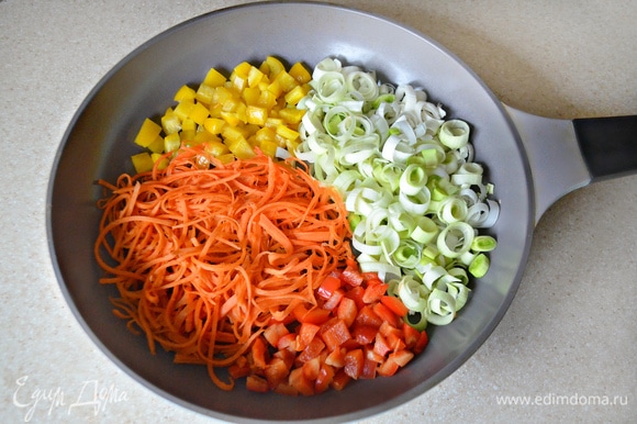 Морковь натрите на терке для корейской моркови или нарежьте очень тонкими полосками, лук–порей нарежьте тонкими кружочками, перец — мелкими кубиками. Овощи слегка обжарьте в сковороде на сливочном масле до мягкости.