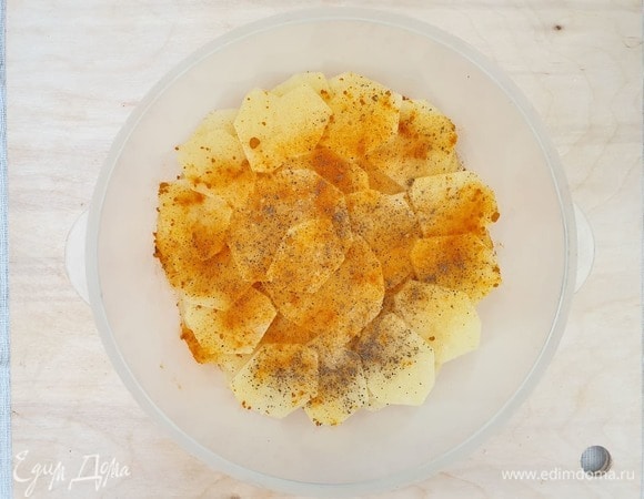 Картофель нарезаем тонкими слайсами. Солим, перчим, посыпаем куркумой и заливаем кипятком. Оставляем на 5 минут.