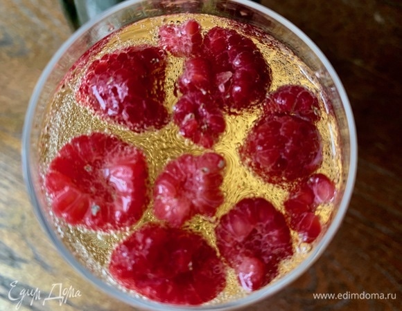 Малиновый ликер хорошо перетереть со свежей малиной, положить в бокал, затем добавить шампанское, ягоды малины.