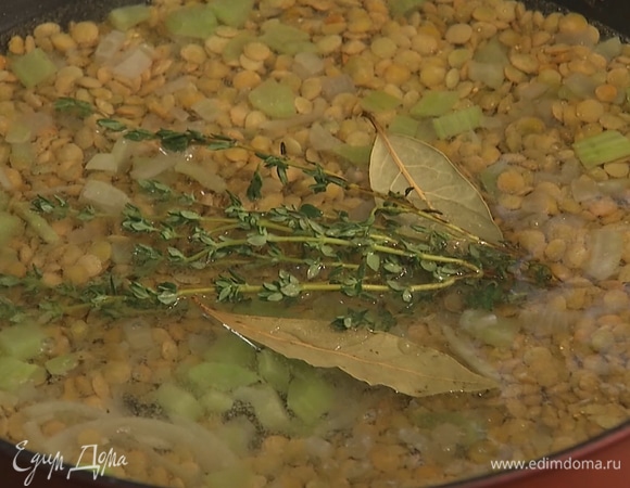 В сковороду добавить чечевицу, все перемешать. Затем залить водой, добавить лавровый лист и тимьян. Накрыть крышкой, тушить 15–20 минут до готовности.