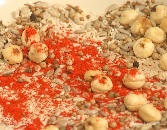 На другую сковороду добавить фундук, семечки подсолнечника, кунжут и все приправы, слегка прогреть.