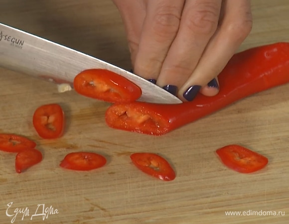 Разогреть сковороду с оливковым маслом. Чеснок и перец чили мелко нарезать, всыпать в сковороду.