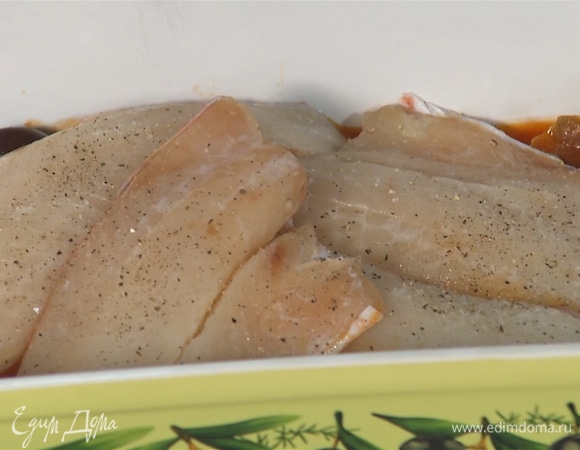 В форму добавить половину соуса, сверху выложить рыбное филе. Посолить, поперчить и посыпать орегано.