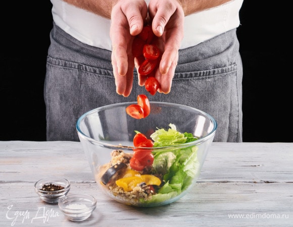 Вымойте салатные листья и выложите их в салатник. Добавьте разрезанные пополам помидоры черри.