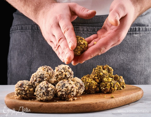 Фисташки и фундук по отдельности измельчите в блендере. Обваляйте вишневые шарики в фундучной крошке, а финиковые — в фисташковой.