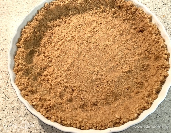 Духовка — на 180°C. Печенье — в крошку при помощи блендера. Масло растопить. Все смешать. Диаметр формы — 22 см. Выложить крошку, хорошо примять. Выпекать 10 минут. Достать, поставить охлаждаться.