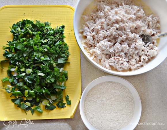 Зелень (зеленый лук, укроп и петрушку) вымойте, просушите и мелко порубите. В сырную смесь добавьте порубленную зелень, муку и мелко нарезанное филе курицы. Хорошо перемешайте.